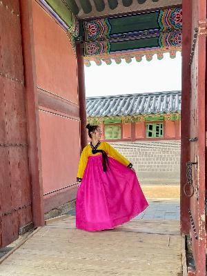 23岁的萨米·塞格达身着韩国传统服饰站在门口.